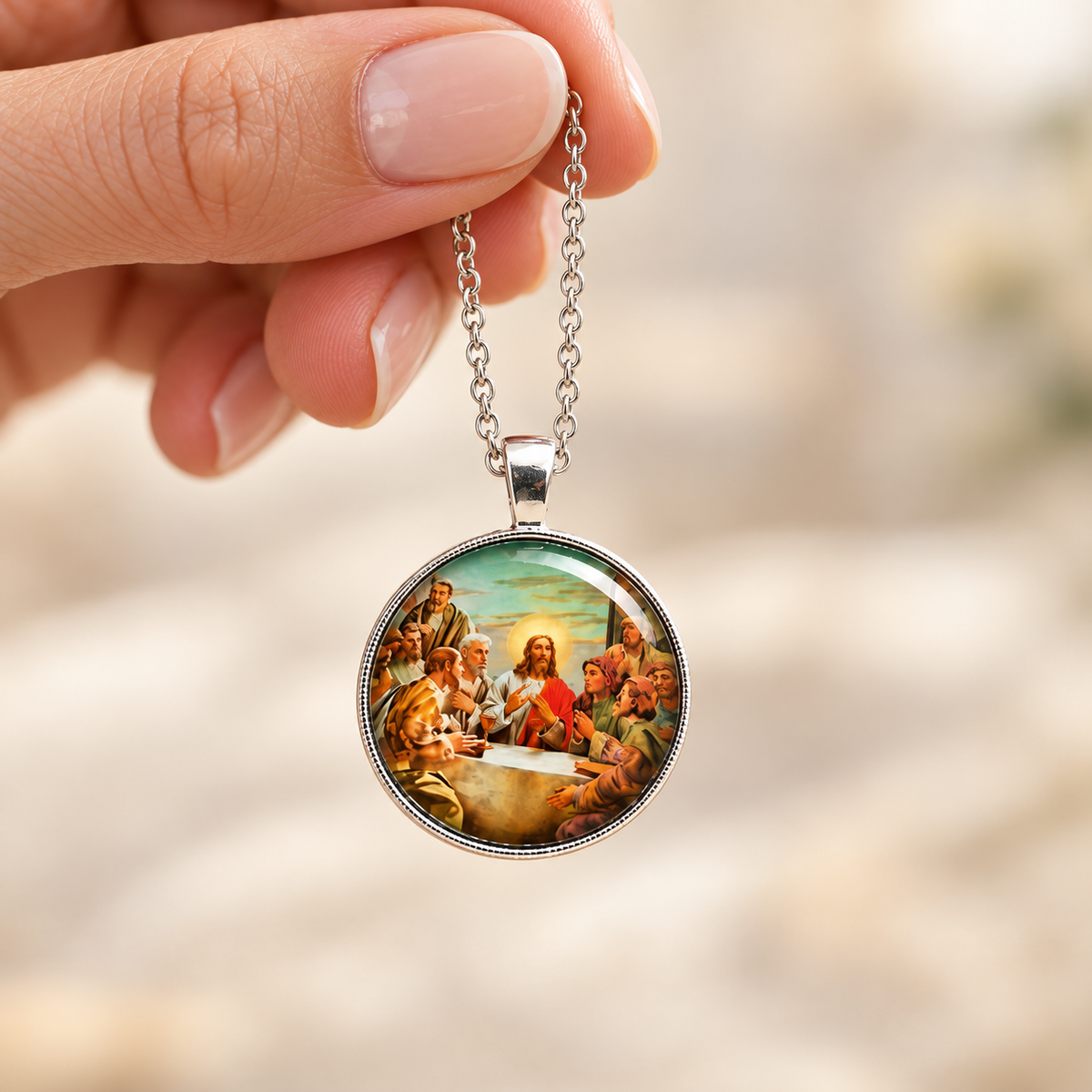 Close-up of a Last Supper necklace being passed between two women’s hands, showing the pendant’s realistic size.