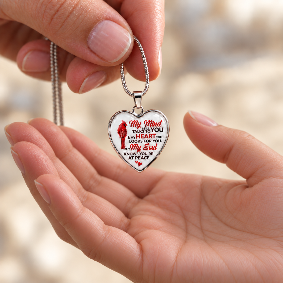image of aheart shaped necklae featuring a cardinal and heartfelt remembrance message