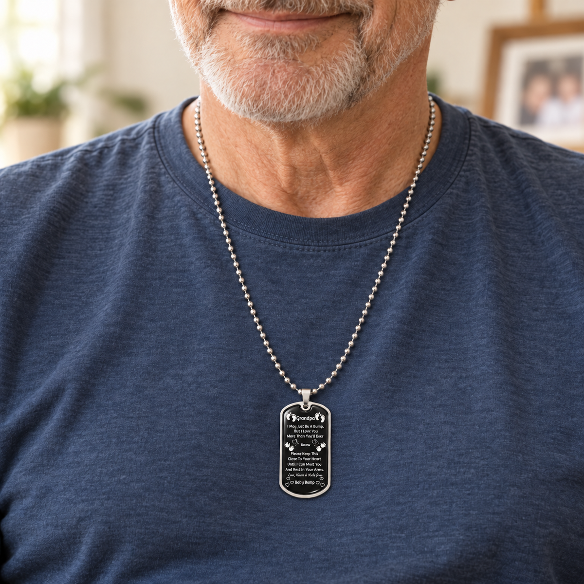 Man wearing a silver-tone Grandpa baby bump dog-tag necklace with a loving message from an unborn grandchild.