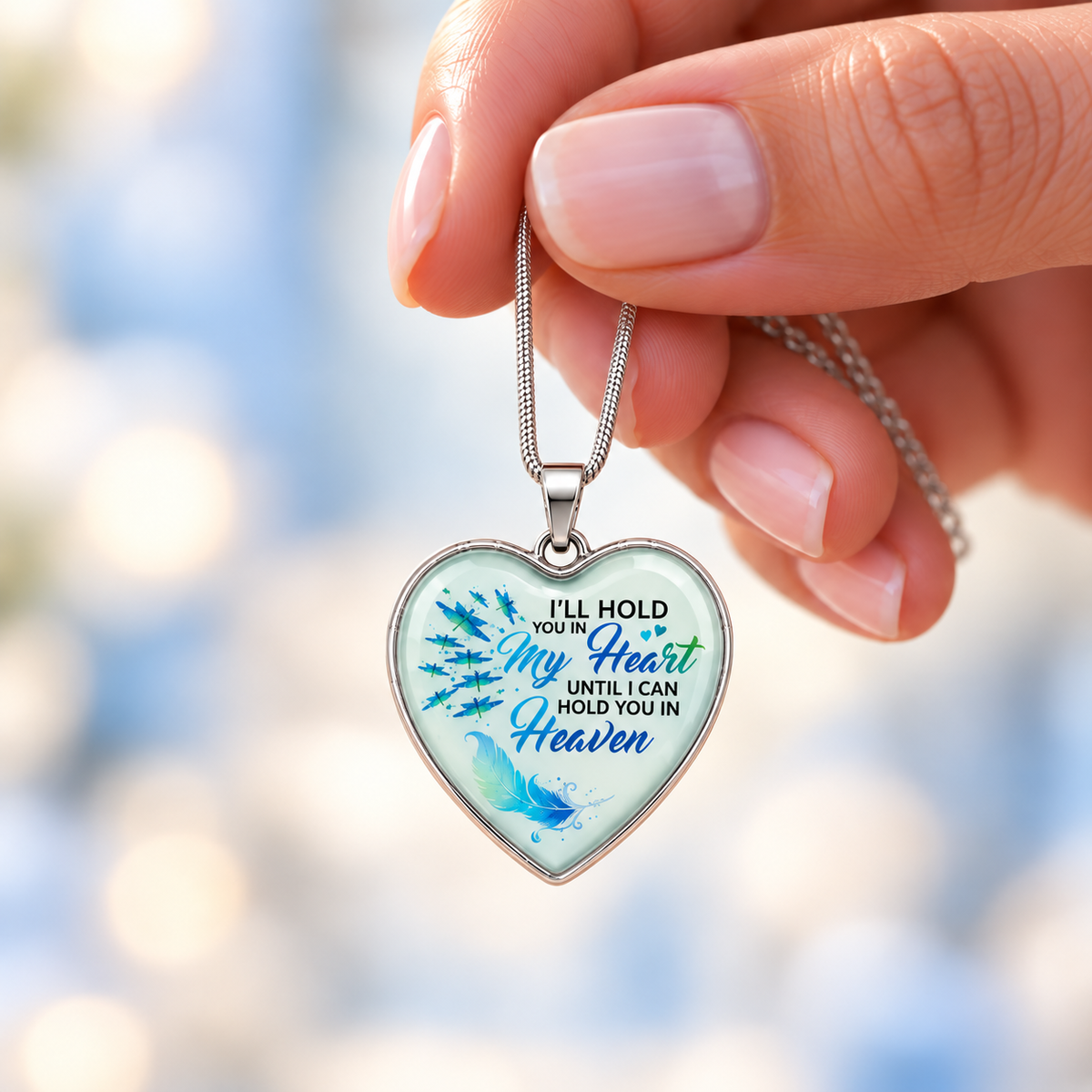 A dragonfly memorial heart necklace featuring the message “I’ll hold you in my heart until I can hold you in Heaven.” A meaningful remembrance gift.
