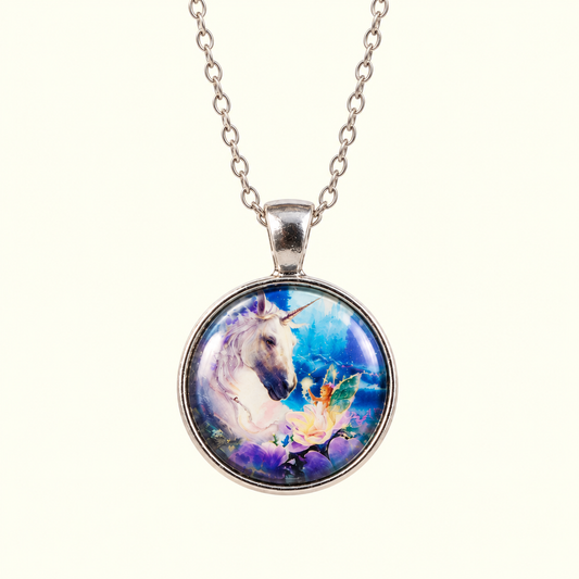 A silver chain necklace with a round pendant featuring a colorful fantasy illustration of a white unicorn and a fairy on a blue and purple background, shown against a light cream backdrop.