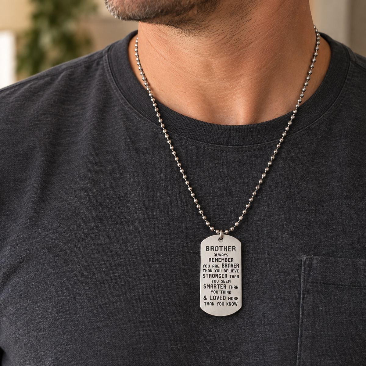 man with a black shirt wearing a dog tag style necklace that reads brother always remember you are braver than you believe stronger than you seem smarter than you think and loved more than you know