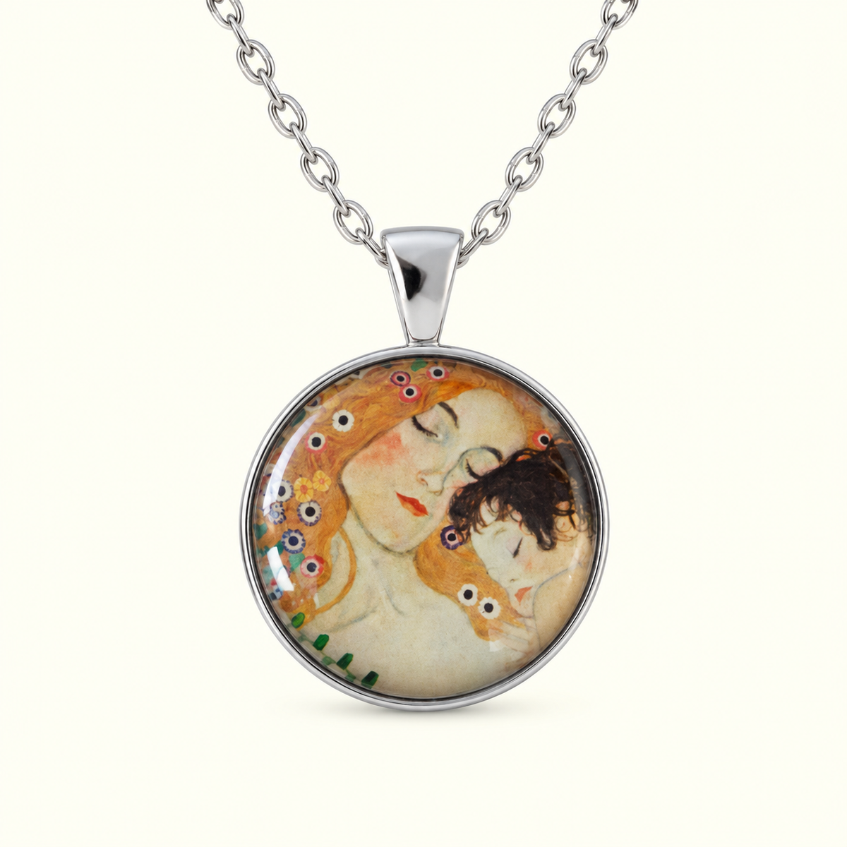 A silver pendant necklace featuring Gustav Klimt's 'The Kiss' artwork, displayed on a clean off-white background.