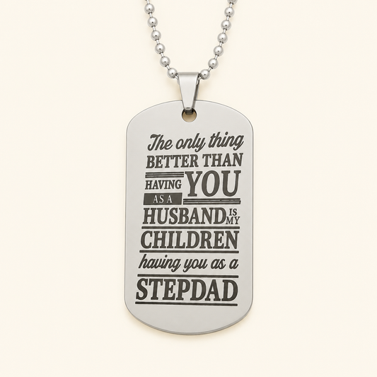 A silver dog tag necklace with a sentimental quote for stepdad, displayed on a light cream background.