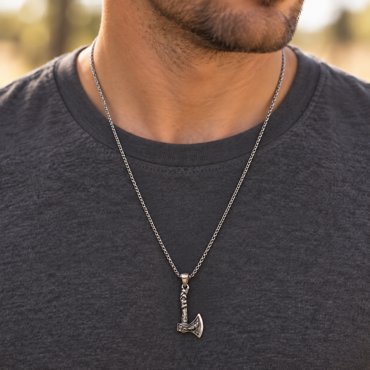 image of a man wearing a silver chain with a hatchet style charm
